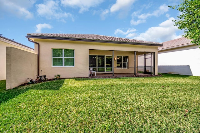 rear view of property with a yard and a sunroom