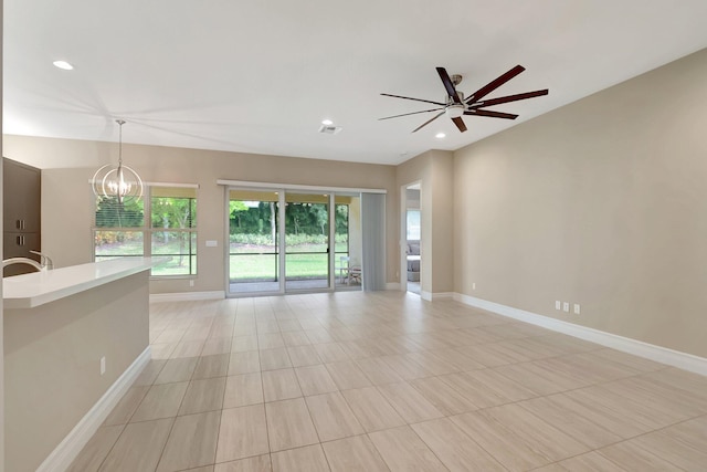 spare room featuring ceiling fan with notable chandelier and sink