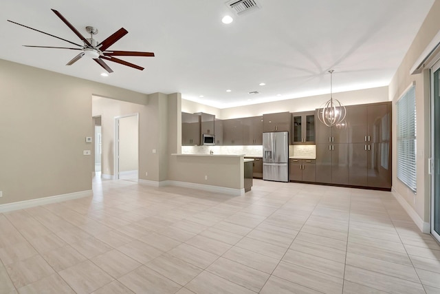 unfurnished living room with ceiling fan with notable chandelier and light tile patterned floors