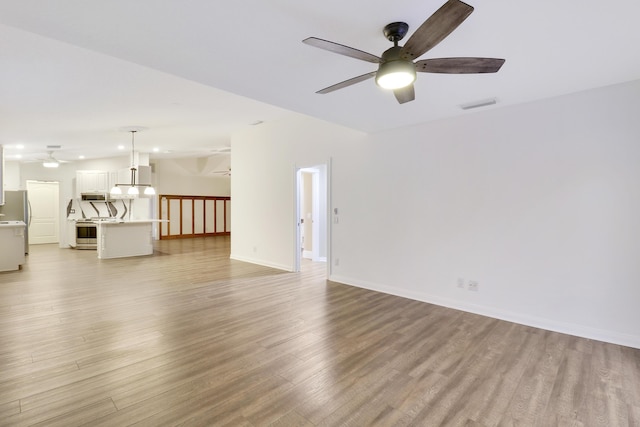 unfurnished living room with ceiling fan and light hardwood / wood-style floors