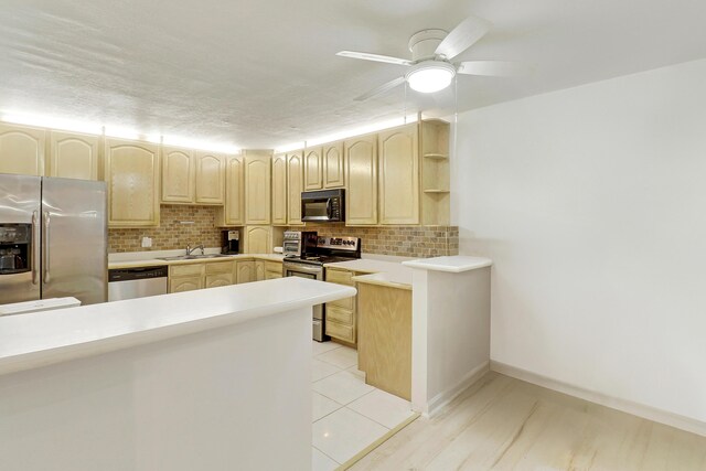 kitchen with ceiling fan, sink, backsplash, light brown cabinetry, and appliances with stainless steel finishes