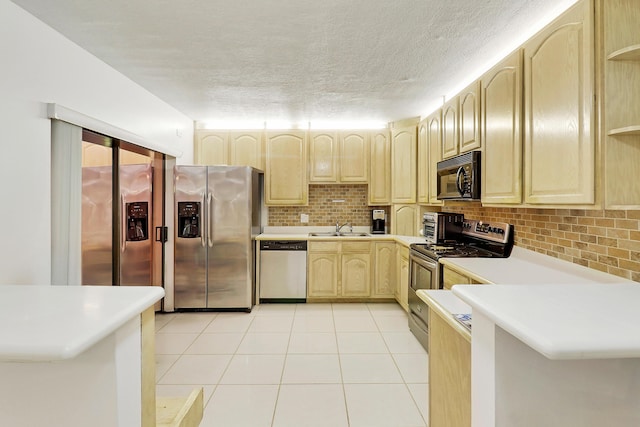 kitchen with kitchen peninsula, light brown cabinetry, stainless steel appliances, sink, and light tile patterned floors