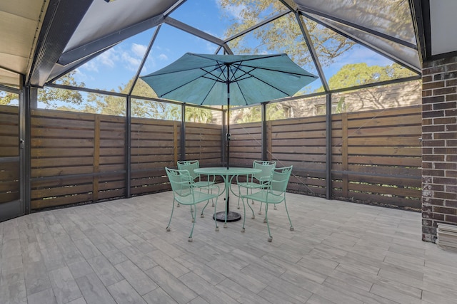 view of patio featuring glass enclosure