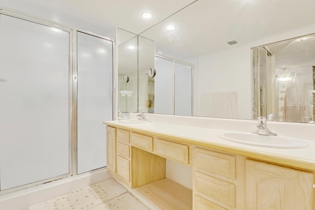 bathroom featuring a shower with door, vanity, and tile patterned flooring