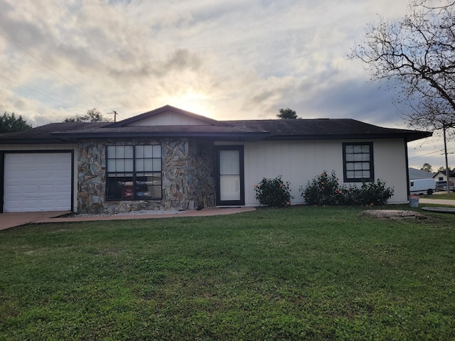 single story home featuring a lawn and a garage