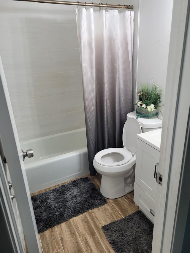 full bathroom with wood-type flooring, shower / bath combo with shower curtain, toilet, and vanity