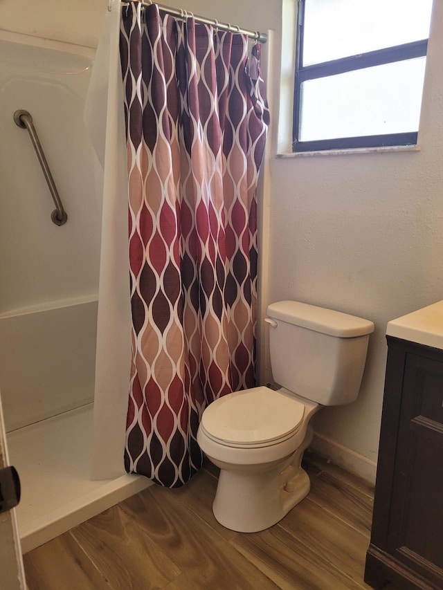 bathroom featuring wood-type flooring, toilet, vanity, and a shower with shower curtain