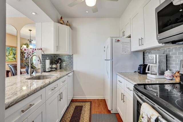 kitchen with backsplash, white cabinetry, and appliances with stainless steel finishes