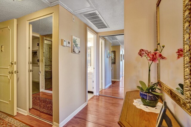 hall featuring a textured ceiling and hardwood / wood-style floors