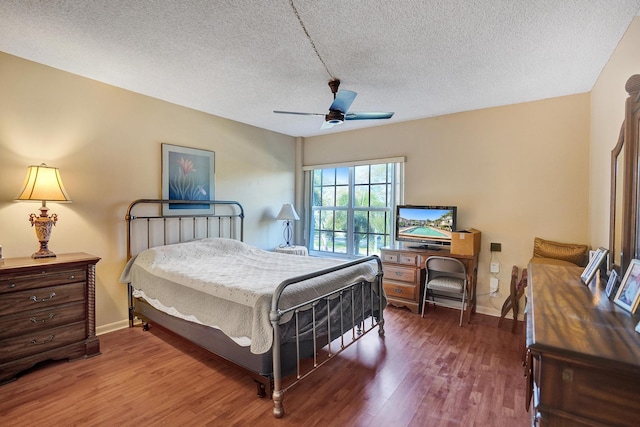 bedroom featuring ceiling fan, a textured ceiling, baseboards, and wood finished floors