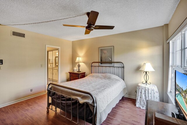 bedroom with ceiling fan, wood-type flooring, and a textured ceiling