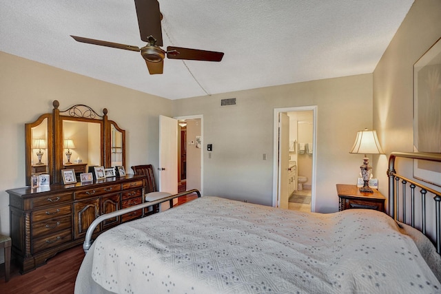 bedroom with connected bathroom, a textured ceiling, visible vents, and wood finished floors