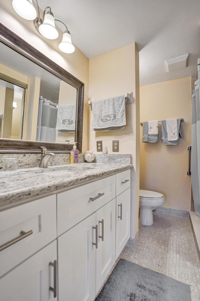 bathroom with curtained shower, vanity, toilet, and tile patterned floors