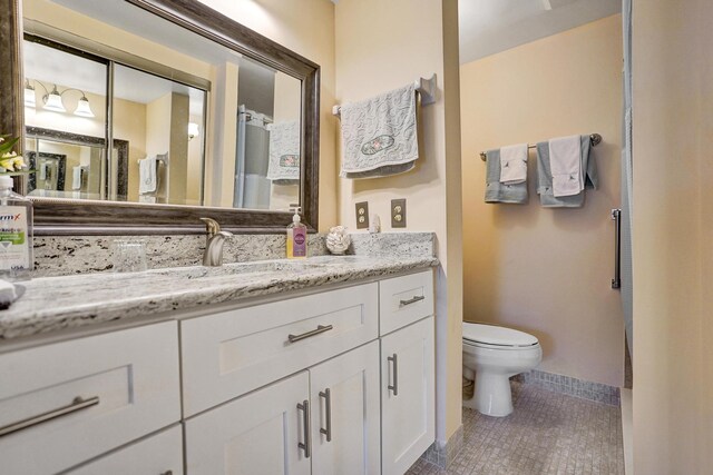 bathroom featuring tile patterned floors, vanity, and toilet