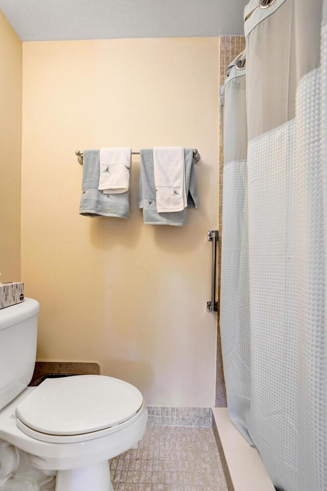 bathroom with toilet, vanity, and tile patterned floors