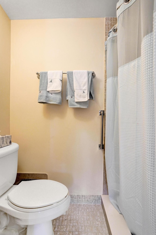 full bath with a shower with shower curtain and toilet
