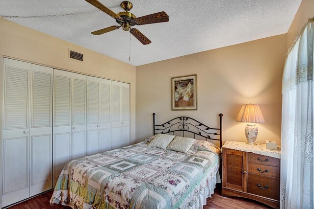 bedroom featuring ceiling fan, dark hardwood / wood-style flooring, and a textured ceiling