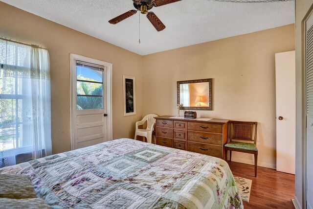 bedroom featuring ceiling fan, a closet, dark wood-type flooring, and a textured ceiling