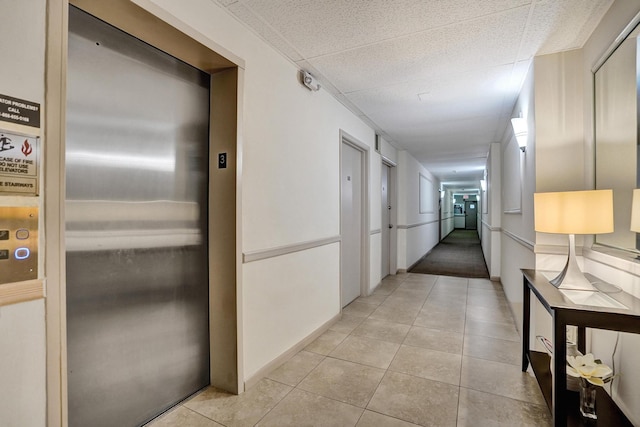 corridor with elevator and light tile patterned flooring