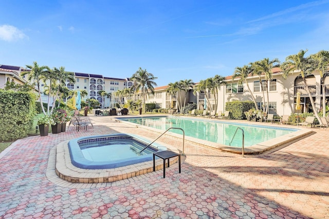 community pool featuring a community hot tub and a patio area