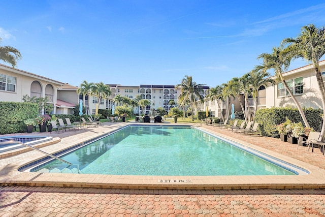 community pool featuring a residential view, a patio, and a community hot tub