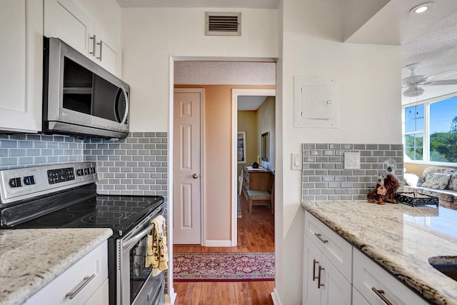 kitchen with visible vents, light wood finished floors, white cabinetry, and stainless steel appliances