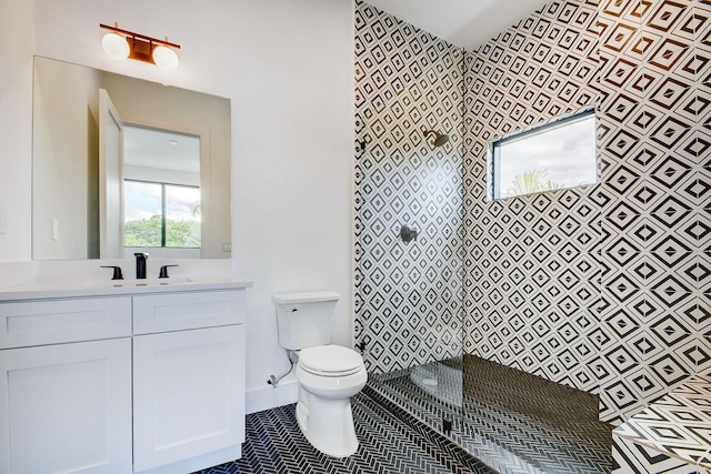 bathroom featuring toilet, vanity, a shower, and tile patterned floors