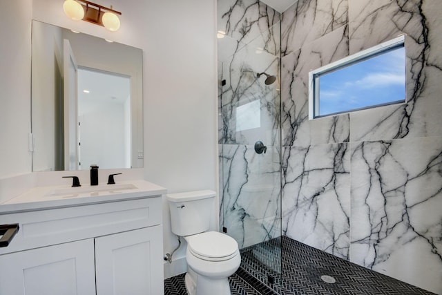 bathroom featuring toilet, vanity, and tiled shower