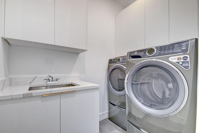 laundry area featuring washer and dryer, cabinets, light tile patterned floors, and sink