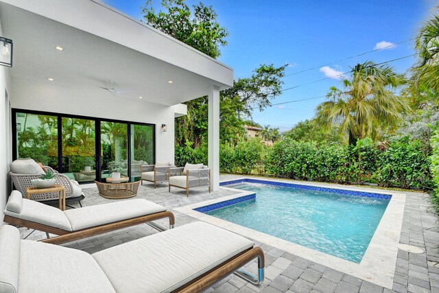 view of swimming pool featuring ceiling fan, an outdoor living space, and a patio