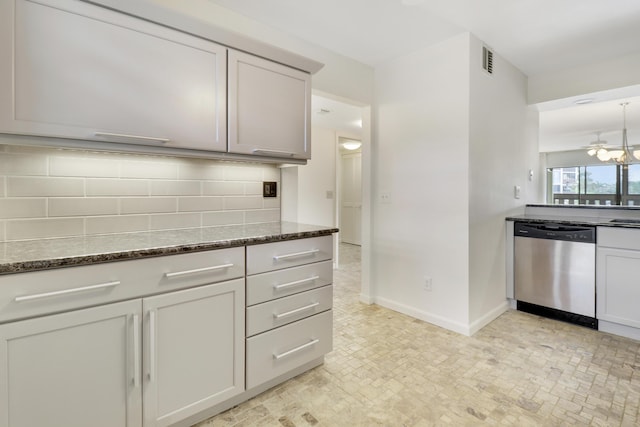 kitchen featuring tasteful backsplash, dark stone counters, and dishwasher