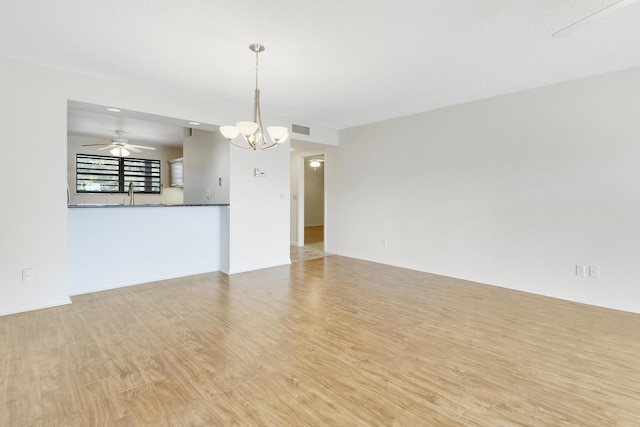 unfurnished living room featuring sink, ceiling fan with notable chandelier, and light hardwood / wood-style floors