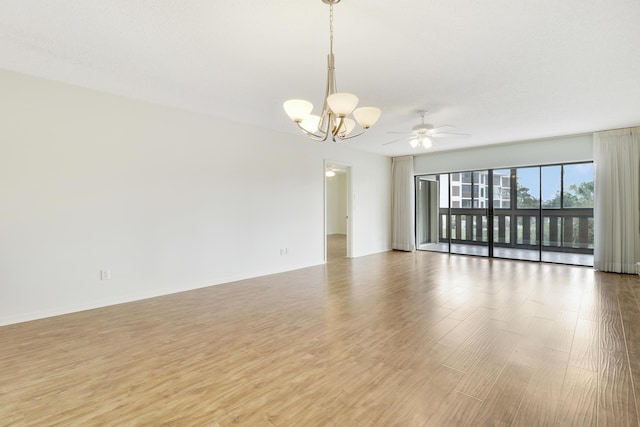 unfurnished room featuring ceiling fan with notable chandelier and light hardwood / wood-style flooring