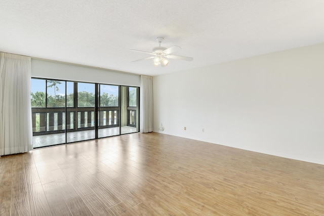 empty room with a textured ceiling, ceiling fan, and light hardwood / wood-style floors