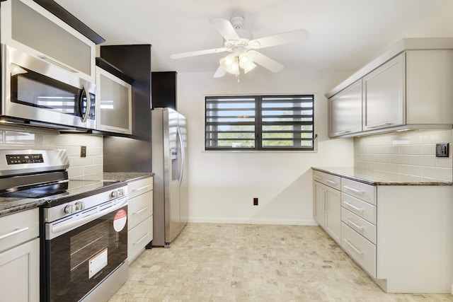 kitchen with dark stone counters, ceiling fan, stainless steel appliances, decorative backsplash, and white cabinets