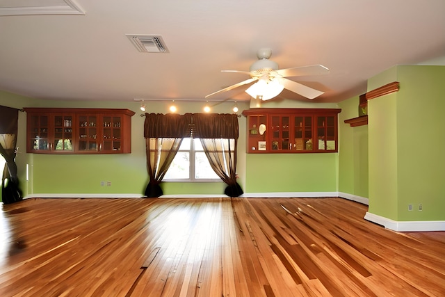 unfurnished living room featuring ceiling fan and hardwood / wood-style flooring