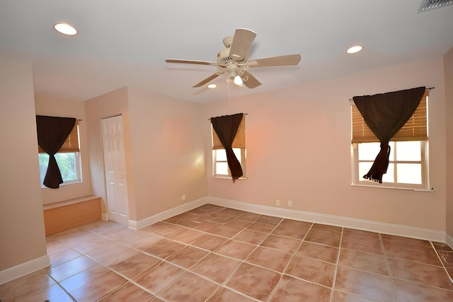 tiled spare room with ceiling fan