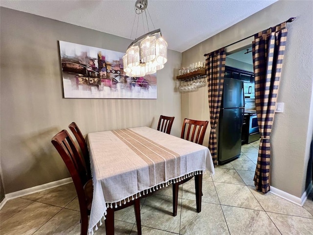 dining space with a textured ceiling, an inviting chandelier, and tile patterned flooring