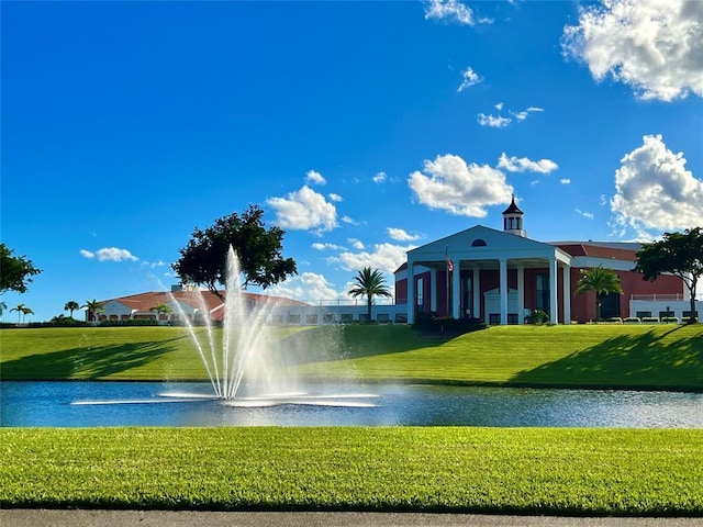 view of community with a lawn and a water view