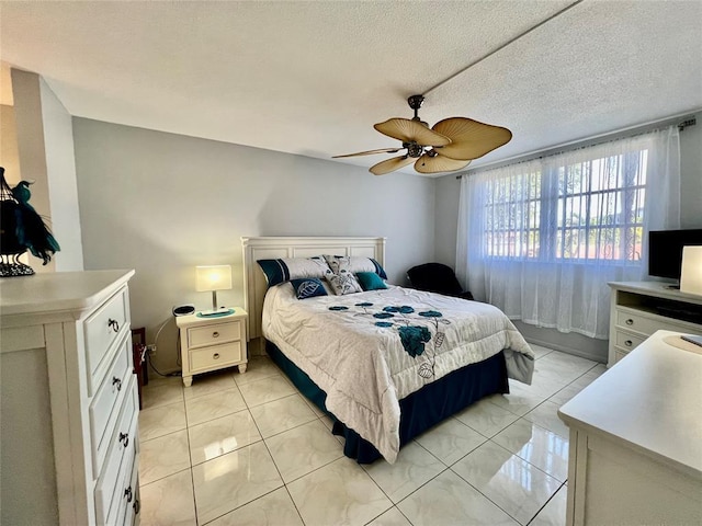 tiled bedroom with ceiling fan and a textured ceiling