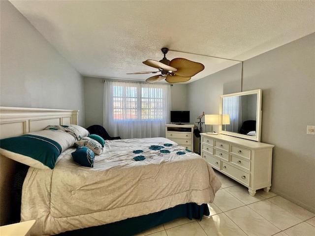 tiled bedroom with ceiling fan and a textured ceiling