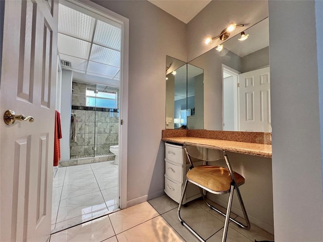 bathroom with vanity, toilet, and a shower with door