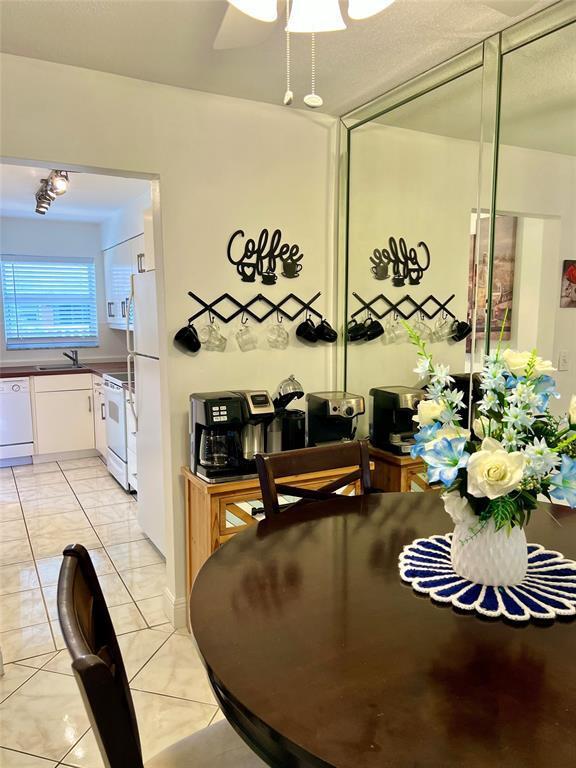 tiled dining space with ceiling fan and sink