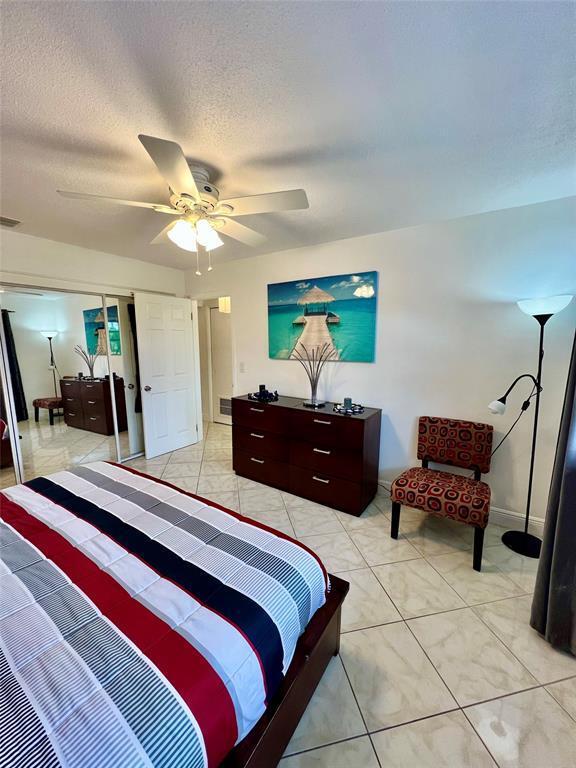 bedroom featuring ceiling fan, a closet, and a textured ceiling