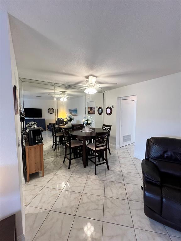 dining area featuring ceiling fan and a textured ceiling