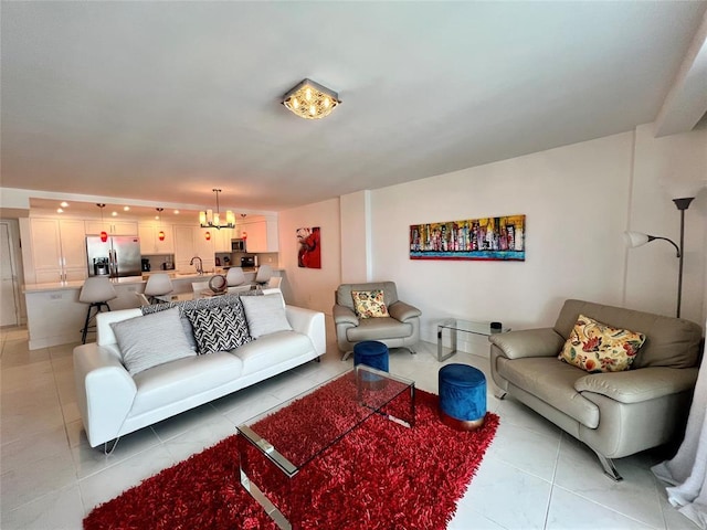 living room with a chandelier, light tile patterned floors, and sink