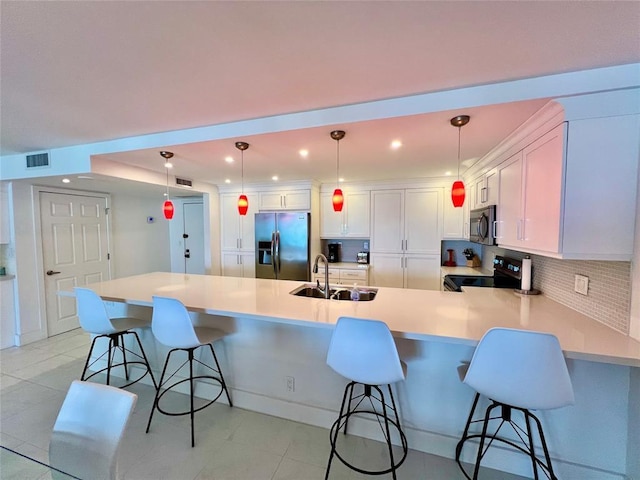 kitchen featuring a breakfast bar, stainless steel fridge, electric range oven, and hanging light fixtures