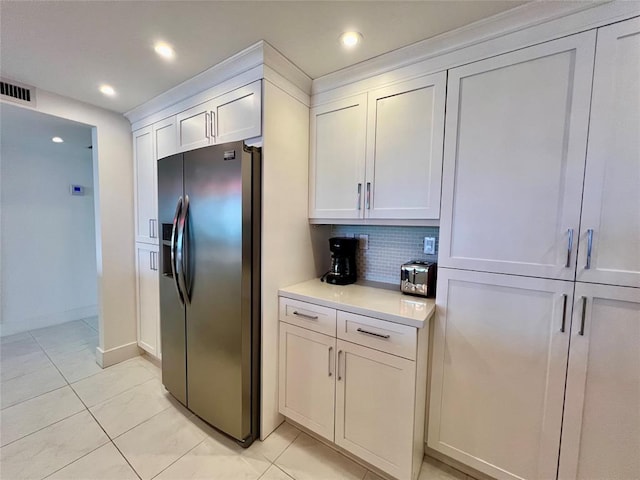 kitchen featuring white cabinetry, backsplash, stainless steel fridge with ice dispenser, and light tile patterned floors