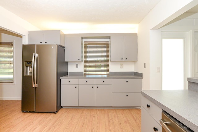 kitchen featuring gray cabinetry, light wood-type flooring, and appliances with stainless steel finishes