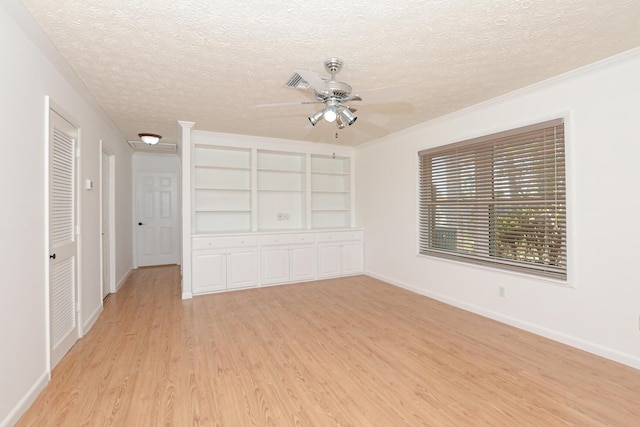 unfurnished room featuring ceiling fan, built in features, a textured ceiling, and light hardwood / wood-style flooring